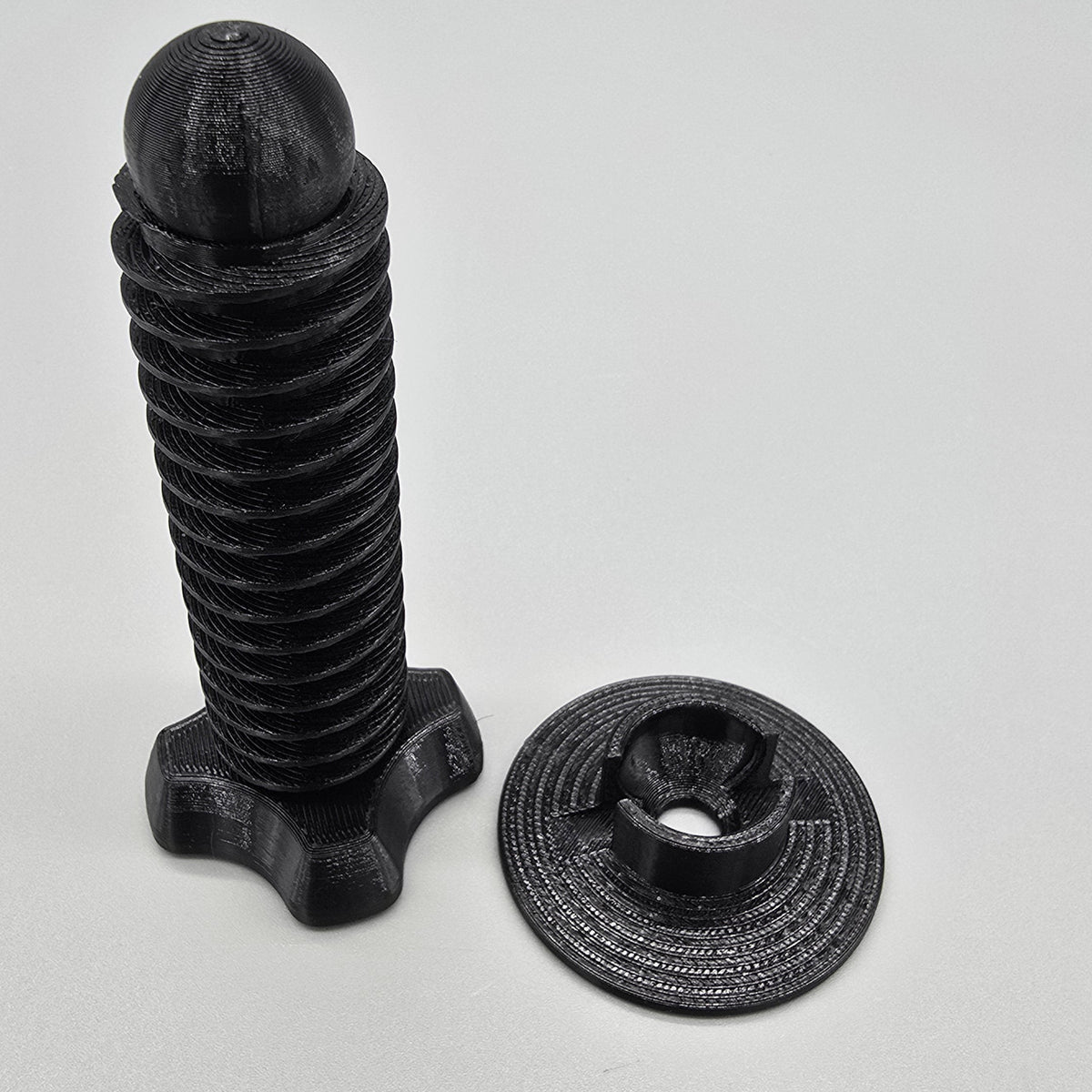 Black metal screw and nut on a light gray background